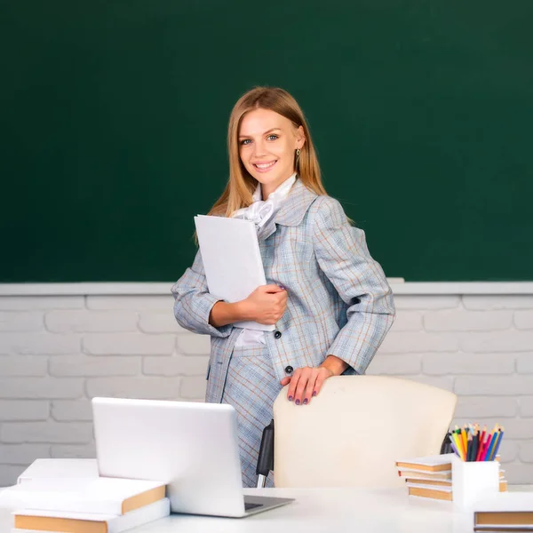 Student holding book on blackboard background, preparing exam and learning lessons in school classroom. — Stock Photo, Image