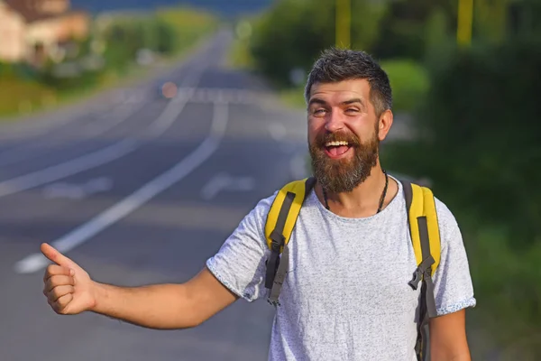 El hombre coge el coche en la carretera, auto dejar de viajar. Parada automática de viaje. El tipo está haciendo autostop. Un hombre está votando en el camino. El hombre intenta dejar de pasar el transporte. Viajar por todo el país. — Foto de Stock