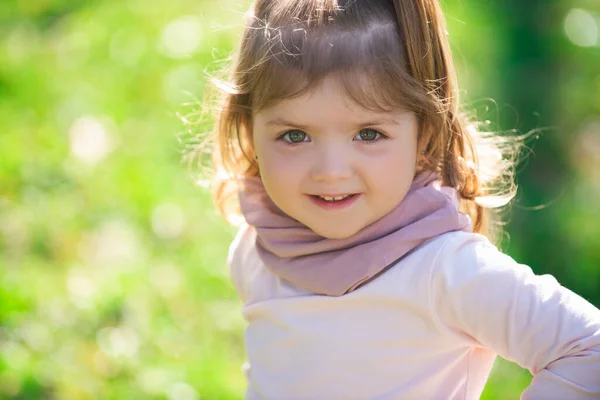 Baby child girl in grass on the fieald at summer. Baby face closeup. Funny little child close up portrait. Blonde kid, smiling emotion face. — Stock Photo, Image