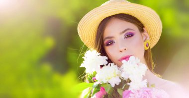 Çiçek açan parkta güzel bir bahar kadını. Bahar çiçekleri içindeki güzel bir kadının portresi. Güzel kadın yüzü. Çiçeklerle çevrili güzel bir genç kadının açık hava moda fotoğrafı..