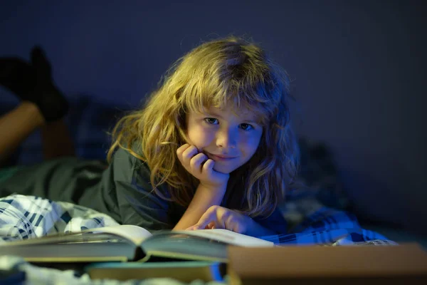 Ребенок читал сказку из книги. Ребенок читает книги. Детям пора спать, мальчик читает книгу в постели. — стоковое фото