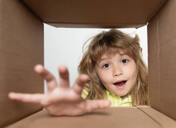 Divertente bambino eccitato disimballaggio e apertura della scatola di cartone guardando dentro. I bambini piccoli unboxing dono vista dall'interno. Bambini scioccati, bambini stupiti emozioni, wow. — Foto Stock