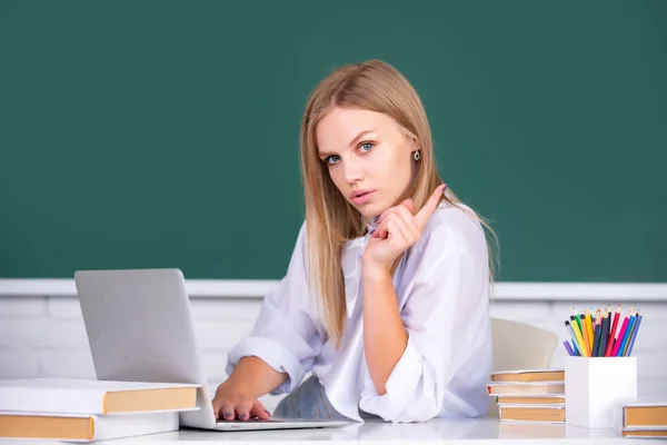 Vrouwelijke studente werkt aan een laptop in de klas, bereidt zich voor op een examen. Mooie Kaukasische vrouwelijke student studeert op afstand, afstandsonderwijs, online onderwijs. — Stockfoto