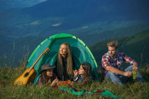 テントの中で幸せな友人のグループキャンプでスイカを食べる。キャンプ友情の話. — ストック写真