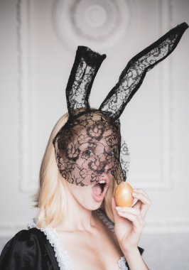 Güzel seksi genç kadın tavşanlı holding Paskalya yortusu yumurta kulaklar ve çok sensually görünüyor. Sürpriz kadın. Mutlu Paskalyalar. Güzel seksi sarışın.