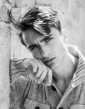 Genç adam kameraya bakıyor. Kendine güveni olan yakışıklı adam..