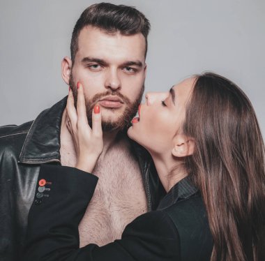 Tüylerine dokun. Tutkulu kırmızı dudaklar ve erkek deri ceketi. Erkek sakalına bayılır. Tutkulu bir kucaklama. Aşık tutkulu bir çift. Acımasız, bakımlı, maço ve çekici kız kucaklaşması.