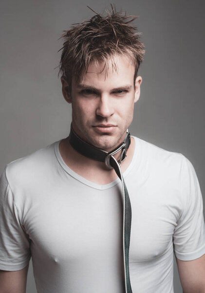 Эротическое удушье. Покорный человек в прелюдии сексуальной игры. Доминировать или подчиняться партнеру. Жестокий красивый мужчина с поясом на шее. Концепция Bdsm. Аутоэротическое удушье. Сексуальный фетишизм
