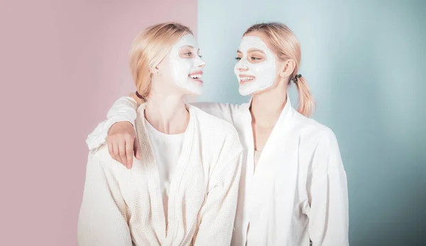 Jonge vrouwen genieten van gezichtsmasker behandeling en hebben een goede tijd met spa procedures. Gezondheid en schoonheid concept. Beste vrienden doen spa procedures en plezier hebben. — Stockfoto