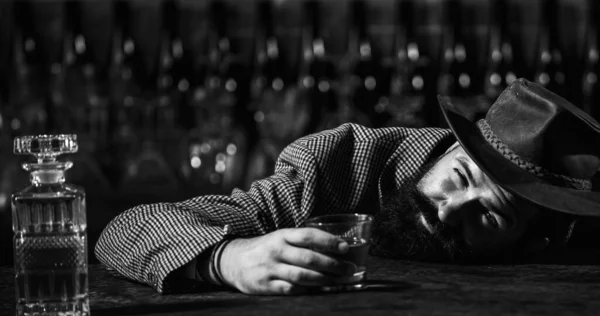 酔った男がガラスを持ってる。ビールパブの睡眠のクライアントとテーブルの上に彼の頭と横たわっ. — ストック写真