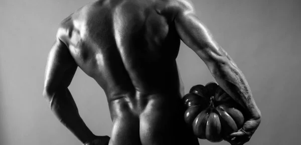 Хэллоуинский мужчина с тыквой и сексуальными ягодицами. Мужчина-красавчик с спортивным телом. — стоковое фото