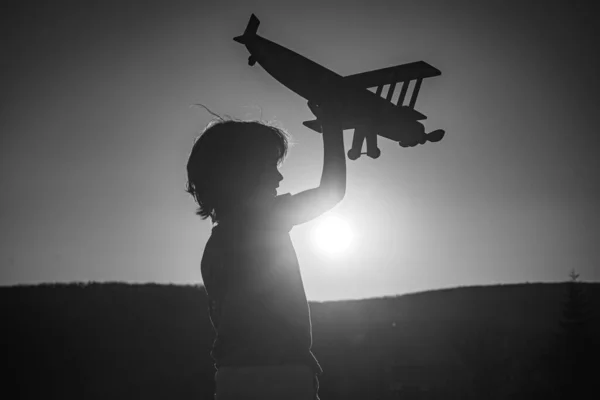Kinderpiloot piloot piloot met vliegtuig droomt van reizen bij zonsondergang. — Stockfoto