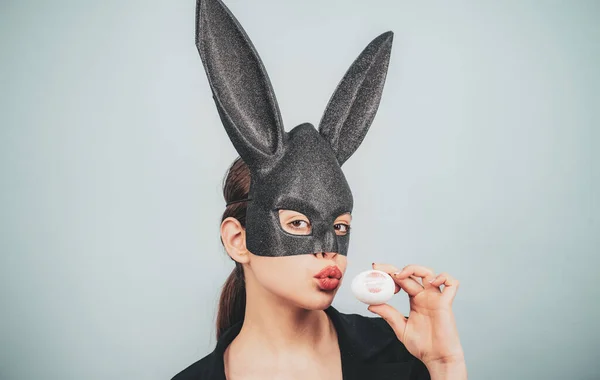 Feliz Páscoa. Menina com orelhas de coelho de renda. Coelhinha da Páscoa, coelho e menina. Batom beijo impressão no ovo de Páscoa . — Fotografia de Stock