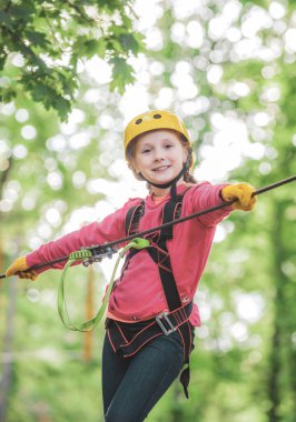 Sevimli okul çocuk bir tırmanma macera aktivite parkı güneşli bir gün zevk. Sanat eserleri uçan tilki veya örümcek ağı içeren eko tatil oyunları tasvir.