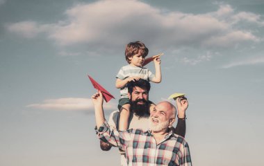 Babalar günü-Büyükbaba, baba ve oğul sarılmak ve birlikte eğlenmek. Uçak uçmaya hazır. Onun omuzlarında oğul piggyback binmek veren ve yukarı bakarak mutlu baba portresi.