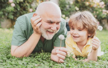 Mutlu son sınıf babasının mutlu ve sevimli oğlunun portresi. Babam ve büyükbabam. Mutlu aile torunu tatilde dedesine sarılır. Mutlu büyükbaba ve torun birlikte rahatlıyor..