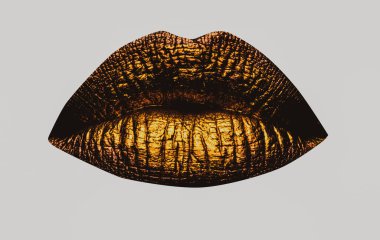 Altın dudaklar yakın çekim. Altın metal dudak. Güzel makyaj. Güzel kadın ağzında altın dudak parlatıcısı, yakın plan. Ağız Simgesi.