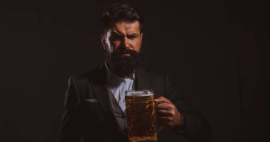 El yapımı bira. Siyaha bir bardak bira içen kendine güvenen bir adam. Degukasyon ve tatma.