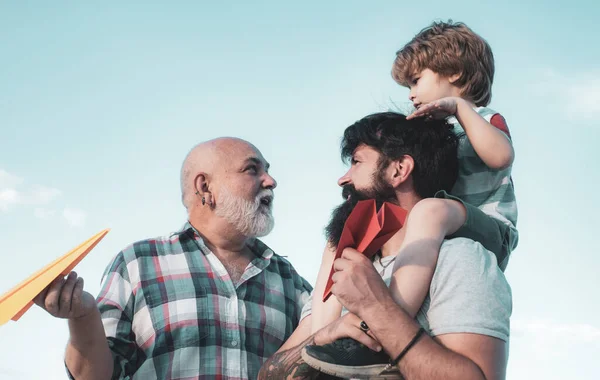 Aile bireyleri. Uçak uçmaya hazır. Erkek çok nesilli bir aile. Gökyüzü arka plan karşı oyuncak jetpack ile çocuk pilot. Mutlu babalar günü. — Stok fotoğraf