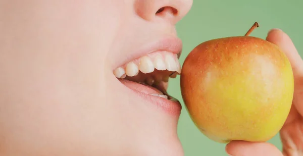 美しい若い女性がリンゴを食べている。健康的な白い歯はリンゴで閉じます. — ストック写真