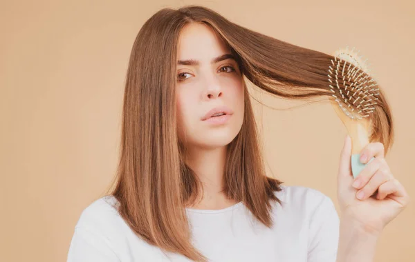 Aantrekkelijke vrouw die haar kamt. Mooi meisje met haarkam kamt haar. Begrip haarverzorging. — Stockfoto