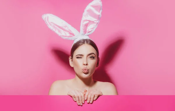 Close-up portrait of attractive cheerful girl wearing pink ears, air kiss. Easter bunny woman. — Stock Photo, Image
