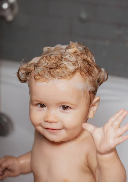 Child bubble bath. Baby bathes in a bath with foam and soap bubbles. — Stock Photo, Image