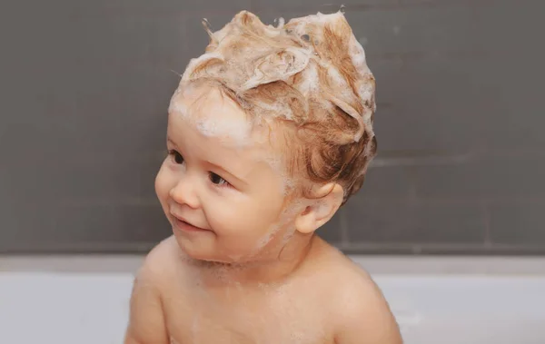 Vicces boldog baba fürdik fürdőkádban vízzel és habbal. A gyerekek higiéniája. Vicces gyerekek közelről.. — Stock Fotó