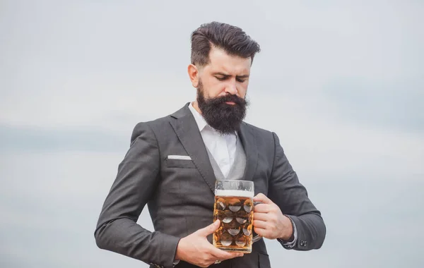 Man in classic suit drinking beer. Portrait of man with lifted high glass of beer. — Stock Photo, Image