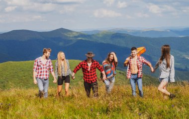 Dağda yürüyüş yapan arkadaşlar. Hafta sonu doğada. İnsanlar güneşli bir günde pikniğin tadını çıkarıyorlar. Yaz tatilleri.