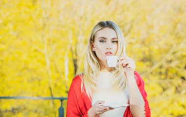 Sonbahar kahvesi. Sonbahar, sonbahar yaprakları, bir fincan kahveli kadın. Mevsimlik, sabah kahvesi. Rahatlatıcı ve durgun yaşam konsepti.