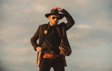 Kovboy şapkalı bir kovboy. Vahşi batı silahları, eski tabanca tabancası ve federal mühimmatı olan ciddi bir adam. Amerikan batı şerifi. Vahşi batı konsepti.