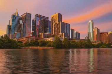Austin, Teksas 'ın merkezindeki Skyline' da. Colorado Nehri 'nde Austin Sunset. Günbatımı şehri. Sudaki yansıma.