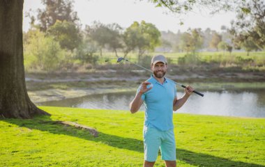 Golfçü yeşil golf topuna vuruyor..