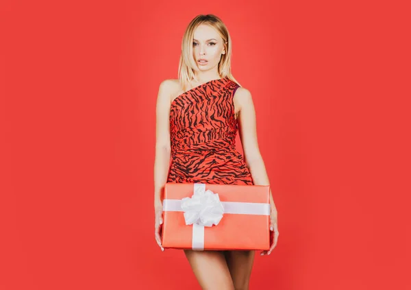 빨간 드레스를 입고 현재 상자를 입은 여성. 동물 무늬 옷을 입은 유행하는 여성. 휴일 축하. — 스톡 사진