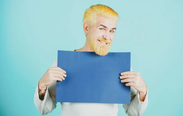 Retrato del hombre feliz guapo posando y sosteniendo la cartelera azul vacía o el tablero blanco azul. —  Fotos de Stock