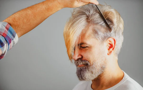 Kuaför erkek saçı kesiyor, yakın plan. Kuaför, profesyonel kuaför salonundaki yakışıklı müşterinin siyah tarağıyla saç yapıyor. Berber konsepti. — Stok fotoğraf