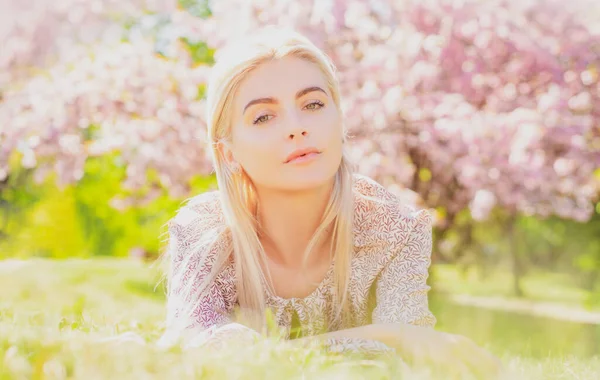 Partrait van sexy jonge vrouw liggend op gras. glimlachend gezicht van lente meisjes. — Stockfoto