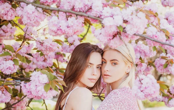 Giovani ragazze e fiori primaverili. Bella donna sexy sensuale in fiori rosa nel parco dei fiori estivi. — Foto Stock