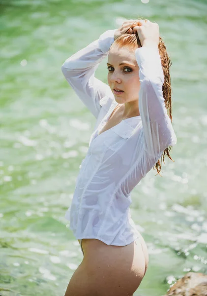 Hermosa joven flotando en el océano o en el agua de mar, relajándose y cuidándose. Retrato de moda de elegante chica linda en vestido de verano durante las vacaciones en el complejo de lujo. —  Fotos de Stock