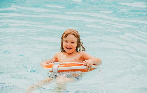 Letnia impreza dla dzieci. Ośrodek basenowy. Uśmiechnięty chłopak w aquaparku. Dziecko pływające w wodzie. Zajęcia na basenie. Aktywny weekend. — Zdjęcie stockowe