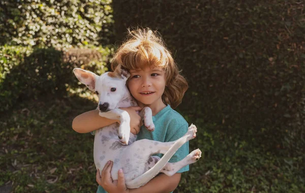 Cão e criança. Filhote de cachorro com criança. Rapaz feliz abraçando e brincando com dogy. Adaptação infantil. — Fotografia de Stock