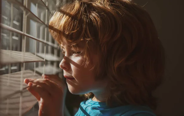 Kind kijkt door het raam. Qarantine concept. Bescherm jezelf. Blijf thuis in zelfisolatie. COVID-19 Afsluiting. Coronaviruspandemie. — Stockfoto