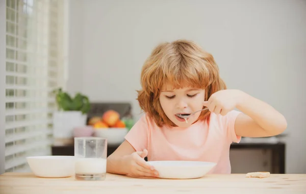 Маленький здоровый голодный мальчик ест суп ложкой. Детское питание. — стоковое фото