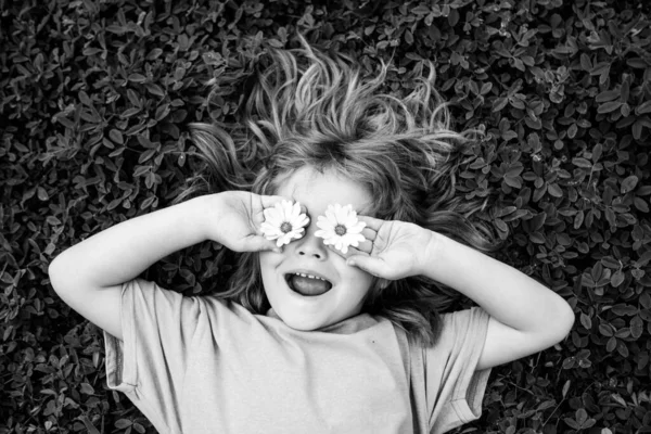 En iyi bahar çocuk portresi. Komik çocuk gülümseyip çimlere uzanıyor. Açık havada, yeşil çimenlerin üzerinde yatan küçük çocuğun komik yüzü. Yaz eğlencesi, mutlu çocukluk. — Stok fotoğraf