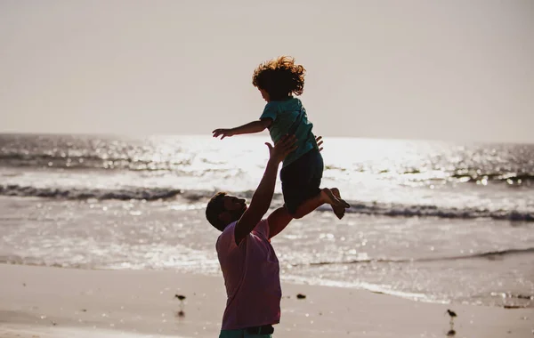 Baba oğlunu mavi gökyüzüne fırlattı. Baba gün batımında çocuk fırlatıyor, siluet. Erkekler üretimi kavramı. — Stok fotoğraf
