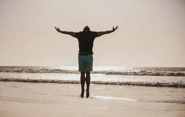 Man jumping on nature. Feel good and freedom concept. Silhouette man jumping on beach. — Stock Photo, Image