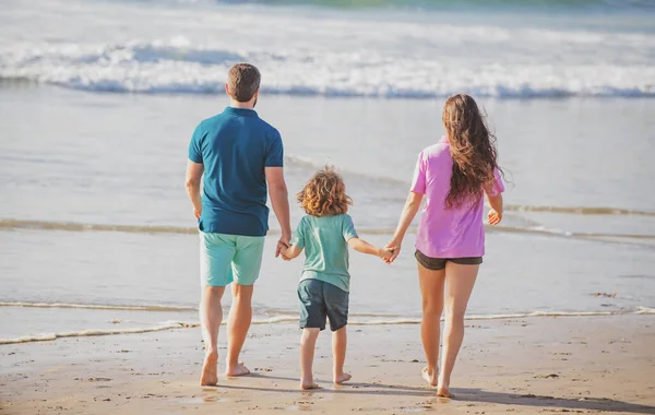 Fijne feestdagen. Vreugdevolle vader, moeder, baby zoon lopen van zee zand strand. Actieve ouders en mensen buitenactiviteiten op zomervakantie met kinderen. Begrip weekendgezin. — Stockfoto