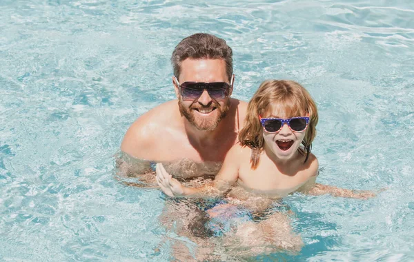 Vader en zoon zwemmen in het zwembad, zomerfamilie. Gelukkige familie in het zwembad tijdens het zomerweekend. Zwemlessen. Vader zoon vrije tijd. — Stockfoto