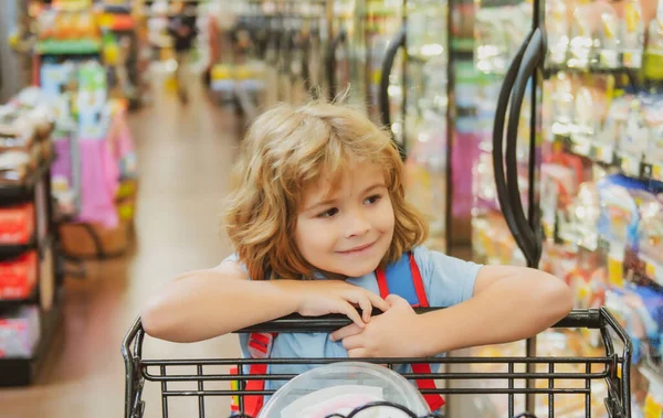 Bambino al supermercato o al supermercato con merci nel carrello della spesa. — Foto Stock